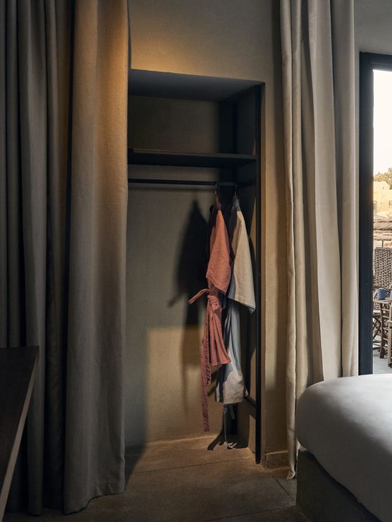 Open wardrobe with a curtain and hanging clothes